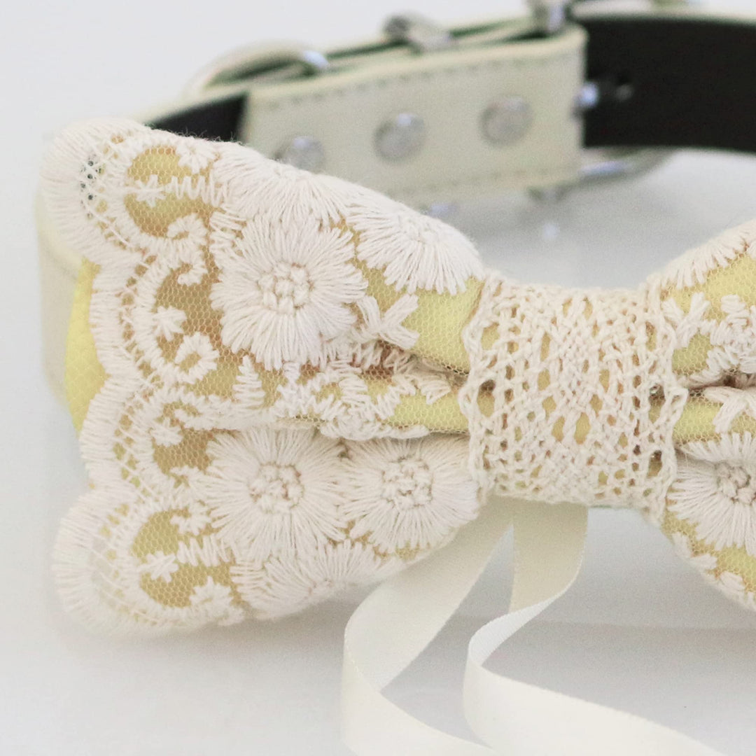 Antique gold lace ring bearer dog bow tie close-up with embroidered floral lace overlay, crochet center detail, and attached wedding ring holder ribbon