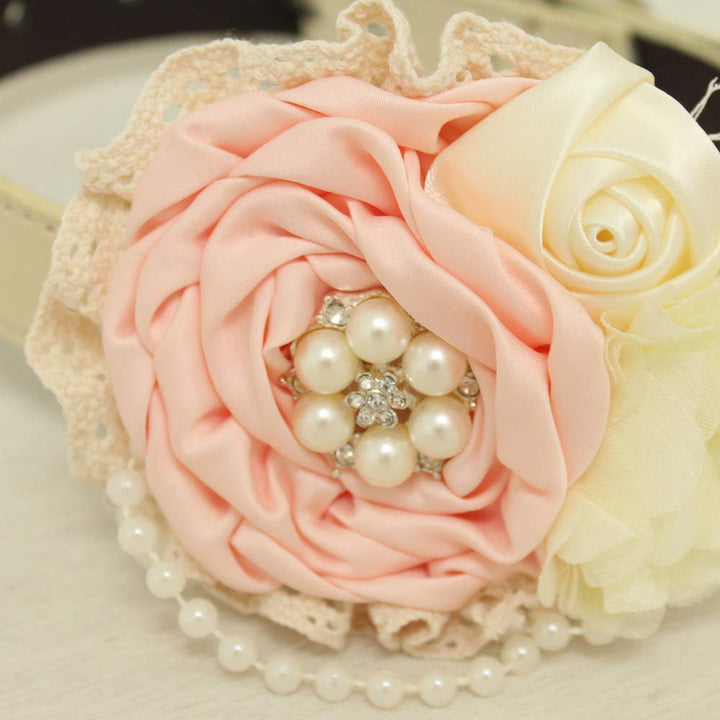 Close-up of blush pink floral dog collar featuring pearl cluster centerpiece, ivory rose, lace details, pearl trim, and layered fabric flowers