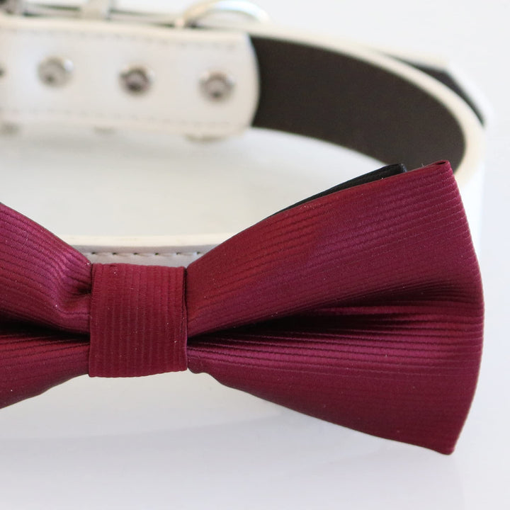 Close-up detail of burgundy ribbed dog bow tie with white vegan leather collar and silver-tone hardware