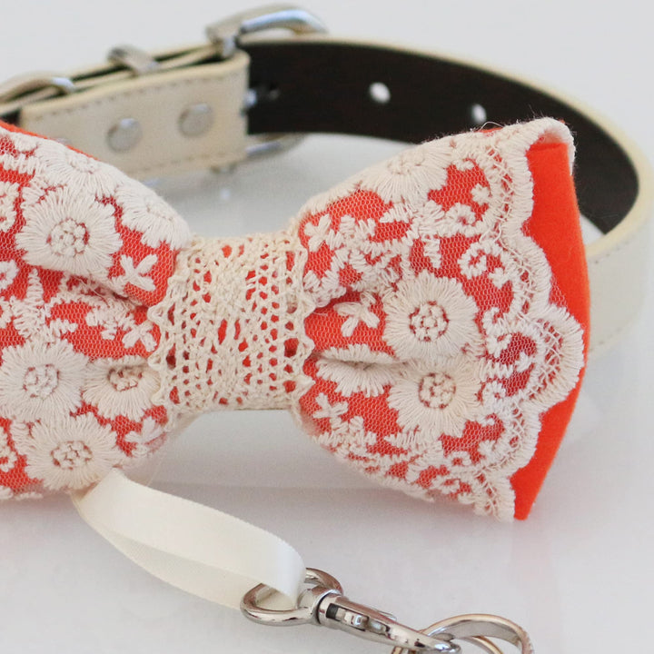 Close-up detail of coral ring bearer dog bow tie featuring embroidered floral lace overlay and attached wedding ring holder ribbon