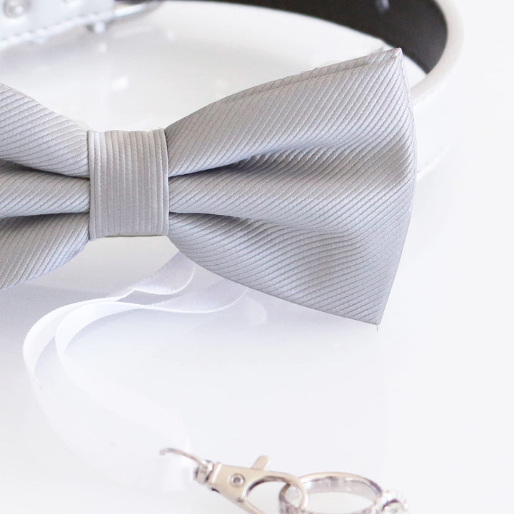 Close-up of a gray striped satin ring bearer dog bow tie with attached ribbon holder.
