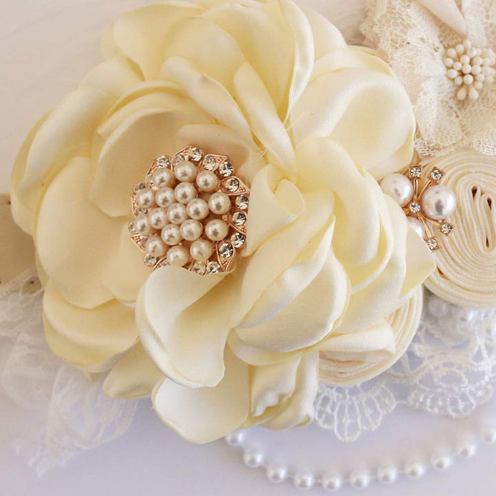 Close-up of an ivory floral dog collar featuring a pearl and crystal centerpiece with lace and pearl accents.