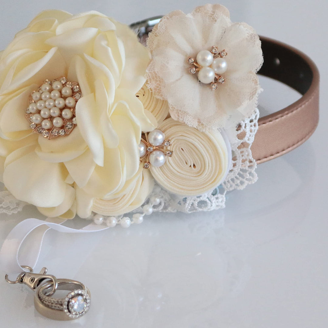 Ivory floral ring bearer dog collar with pearl centerpiece, lace flower accent, decorative rosettes, and ring holder charm.