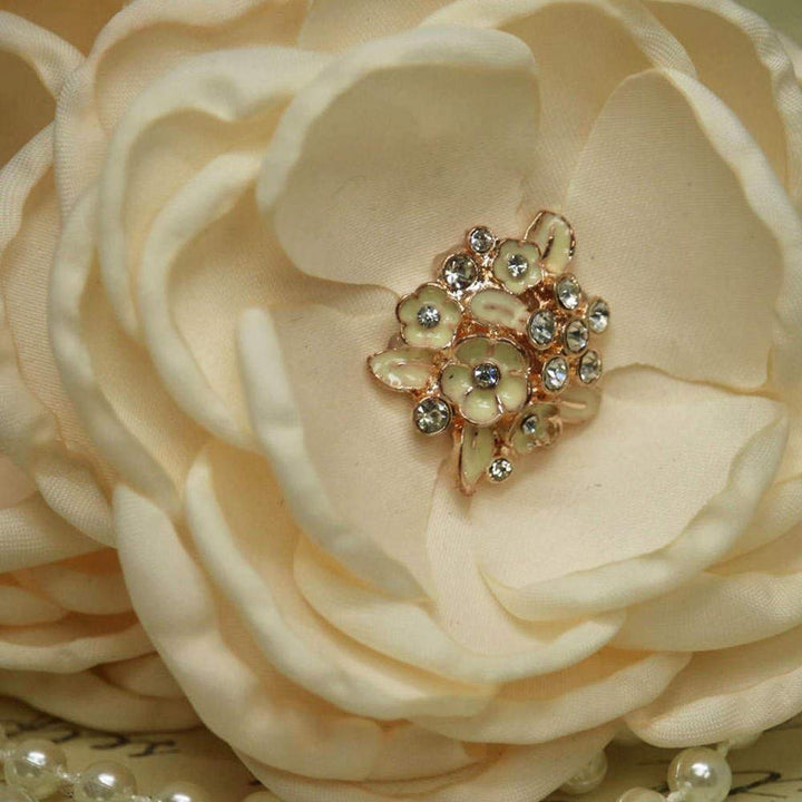 Close-up of an ivory fabric flower with crystal and enamel floral center detail on a dog collar.