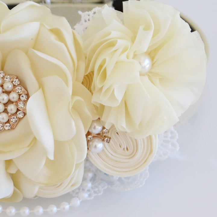 Close-up of ivory floral dog collar featuring pearl and crystal centerpiece with handcrafted flower petals.