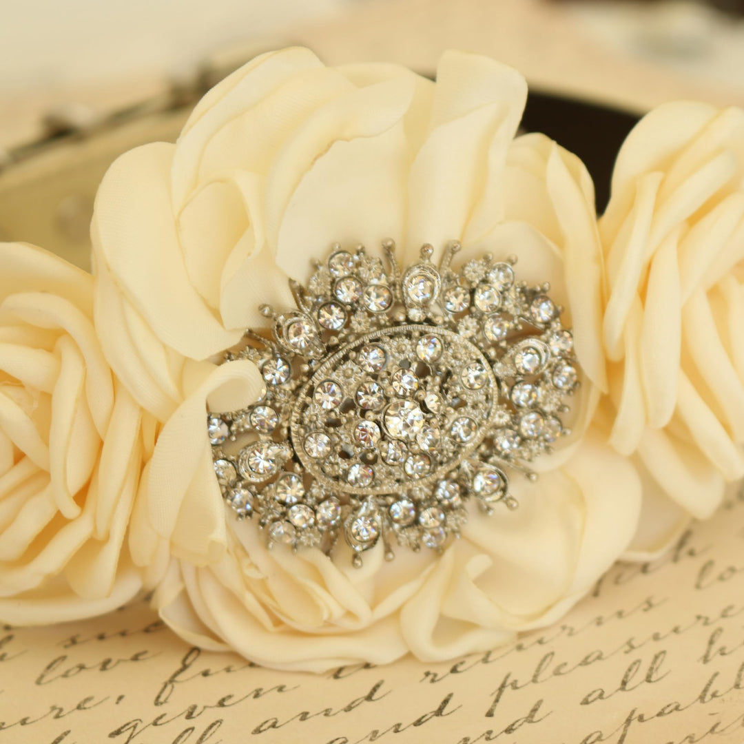 Close-up of ivory floral dog collar featuring a rhinestone brooch centerpiece and handcrafted rose flowers.