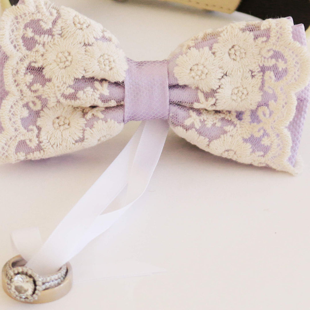 Lilac ring bearer dog bow tie close-up with embroidered floral lace overlay, attached wedding ring holder ribbon, and elegant wedding design