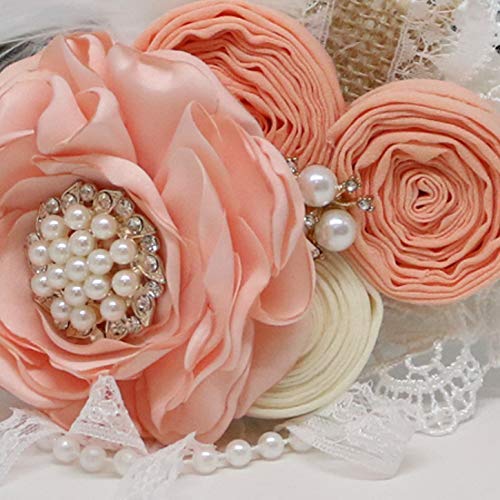 Close-up of peach satin flower with pearl and rhinestone centerpiece, rolled fabric flowers, lace accents, and pearl details