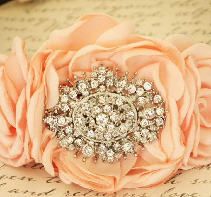 Close-up of peach fabric rose dog collar with ornate rhinestone crystal centerpiece and handmade floral details
