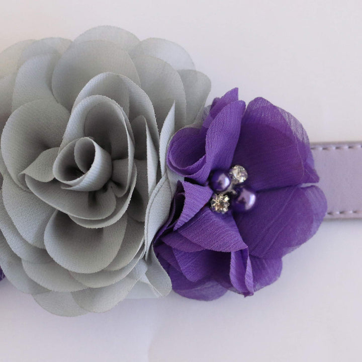Close-up of gray and purple floral dog collar with layered fabric flowers, pearl accents, and crystal details.