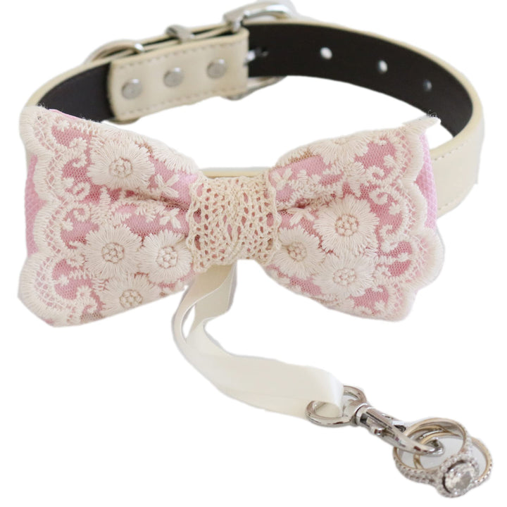 Soft pink lace ring bearer dog bow tie collar with embroidered floral lace design, attached wedding ring holder ribbon, decorative ring charm, and adjustable vegan leather collar for weddings and special occasions