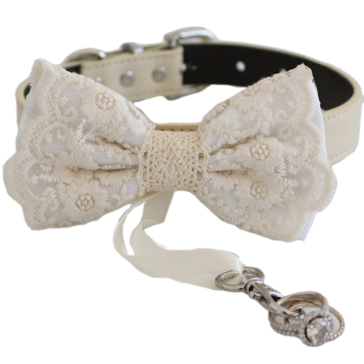White lace ring bearer dog bow tie collar featuring embroidered floral lace pattern, attached wedding ring holder ribbon, decorative ring charm, and adjustable vegan leather collar for weddings and formal ceremonies