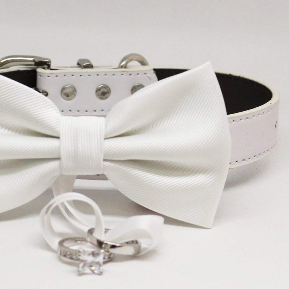 Close-up of a white ring bearer dog bow tie with wedding ring holder ribbon.