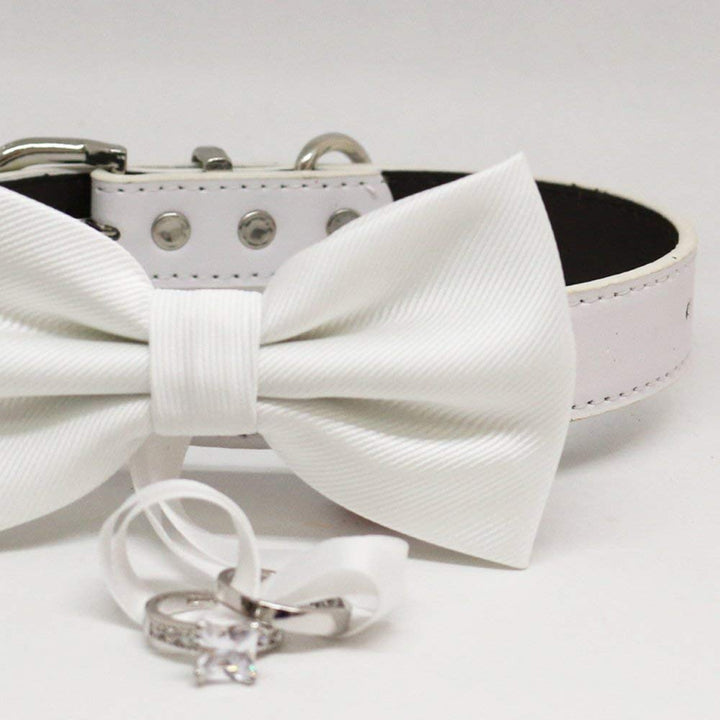 Close-up of a white ring bearer dog bow tie with wedding ring holder ribbon.