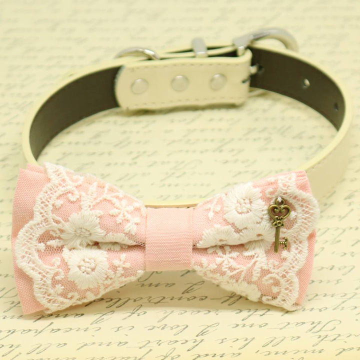 Blush pink lace dog bow tie collar with antique bronze key charm, floral embroidered lace overlay, cream vegan leather collar, and elegant vintage-inspired design