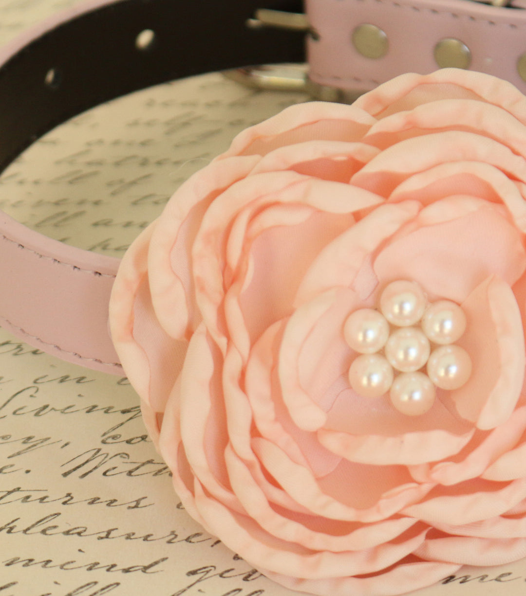 Close-up of blush pink peony style floral dog collar with pearl center detail and layered fabric petals