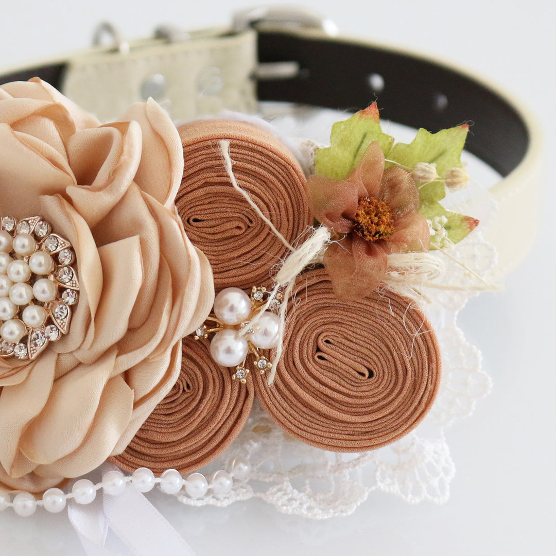 Close-up of champagne country style ring bearer dog collar with pearl flower centerpiece, rosette flowers, lace accents, rustic floral details, and wedding ring holder ribbon.