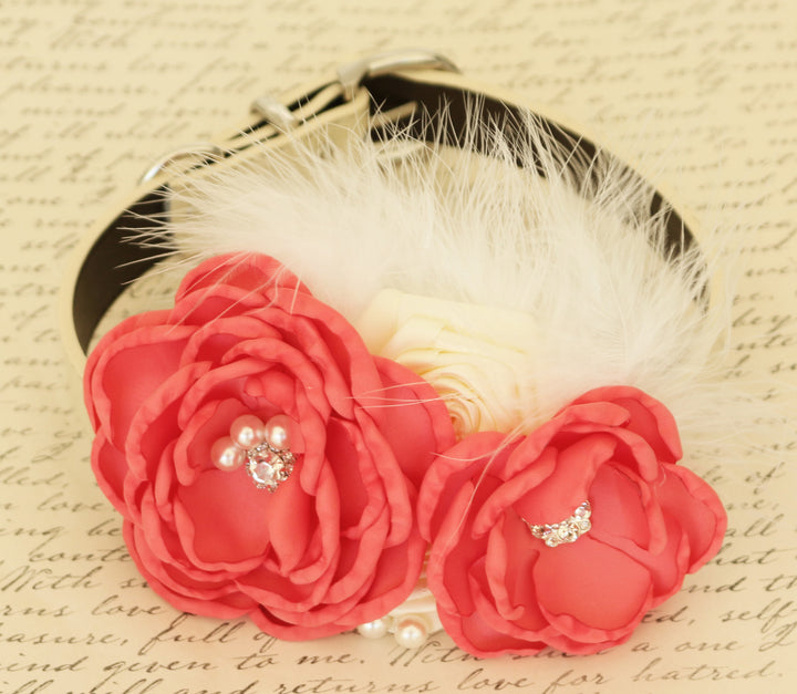 Coral and ivory ring bearer dog collar featuring handcrafted flowers, white feather accents, pearl embellishments, adjustable vegan leather collar, and elegant wedding styling.