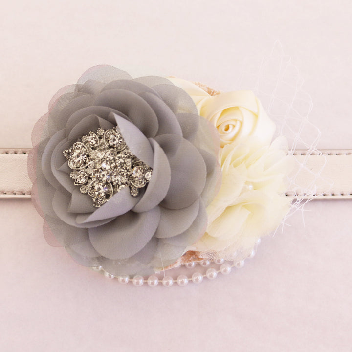 Close-up of gray chiffon flower dog collar with ivory rose accents, pearl strand detail, crystal brooch, and decorative veil.