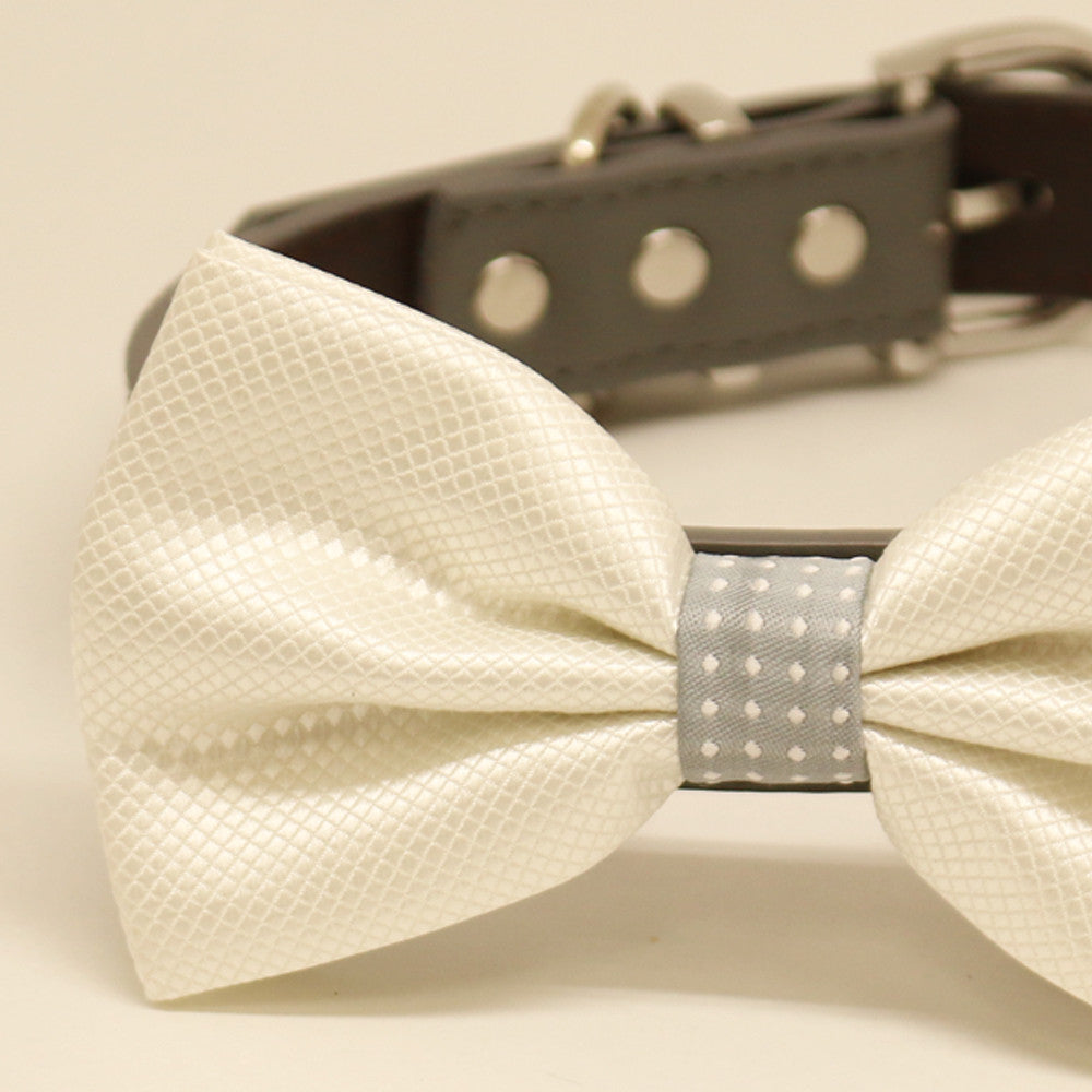 Close-up of ivory white dog bow tie with textured satin fabric and gray polka dot center accent