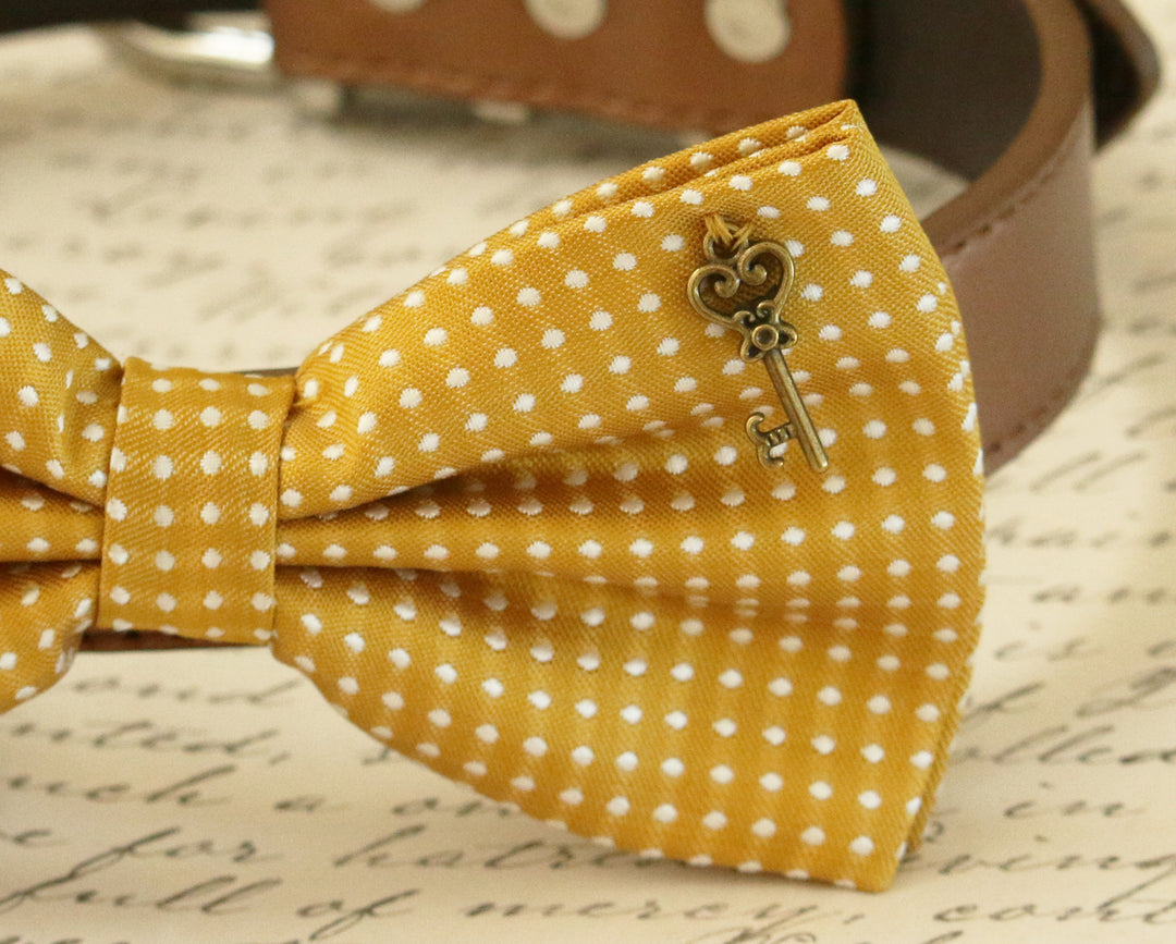 Close-up of mustard yellow polka dot dog bow tie with vintage key charm detail