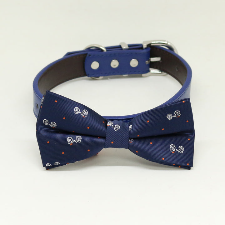 Navy blue dog bow tie collar with white carriage motifs, orange accent dots, and matching vegan leather collar