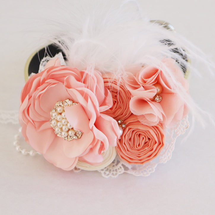 Handcrafted peach floral dog collar with lace trim, pearl accents, decorative feathers, and wedding-inspired flower arrangement.
