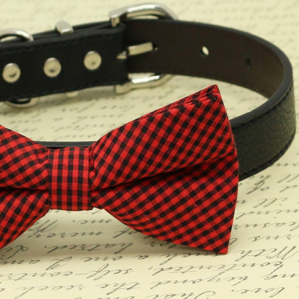 Close-up view of a red and black gingham check dog bow tie attached to a black vegan leather collar.