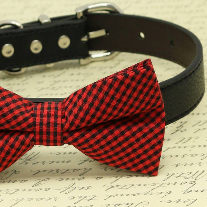 Close-up view of a red and black gingham check dog bow tie attached to a black vegan leather collar.