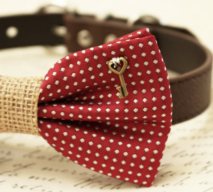 Close-up of red polka dot dog bow tie with decorative key charm and burlap center accent.