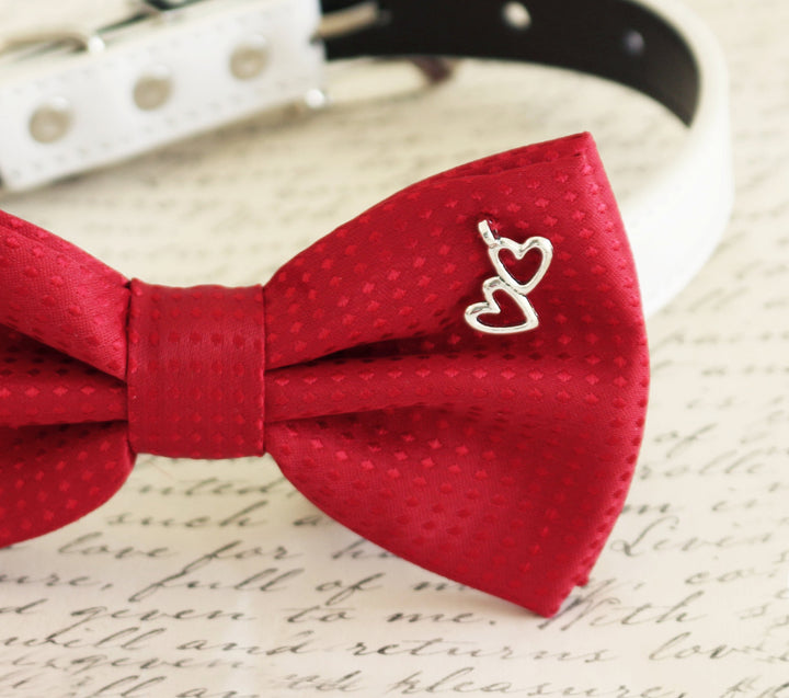 Close-up of red satin dog bow tie with double heart charm detail.