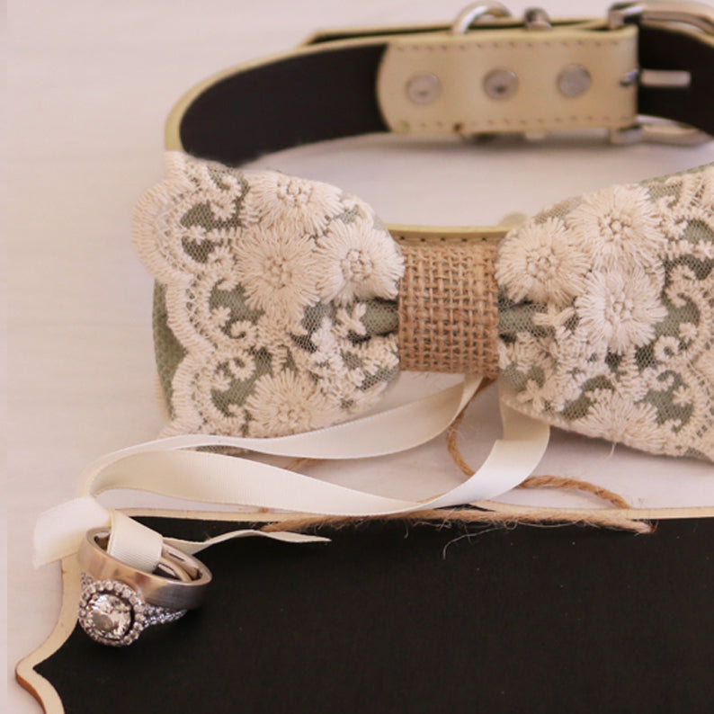 Sage green lace ring bearer dog bow tie collar displayed with attached wedding ring holder ribbon, decorative ring, and rustic wedding signboard