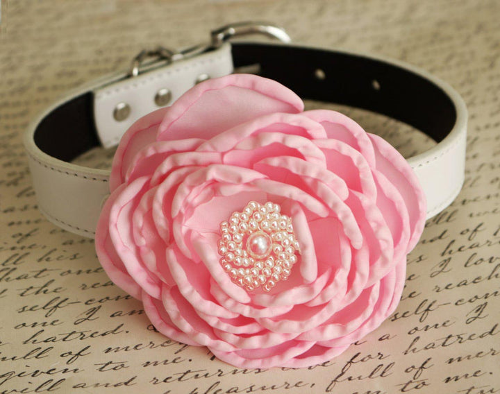 Soft pink floral dog collar with layered flower petals and pearl centerpiece on a white vegan leather collar