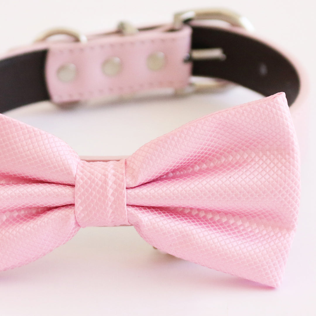 Close-up of a soft pink textured satin dog bow tie with subtle diamond pattern.