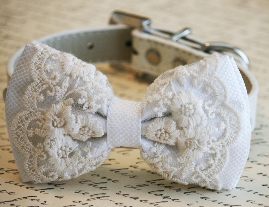 White lace dog bow tie collar with floral embroidered lace, textured white center accent, and adjustable vegan leather collar displayed on a vintage handwritten paper background