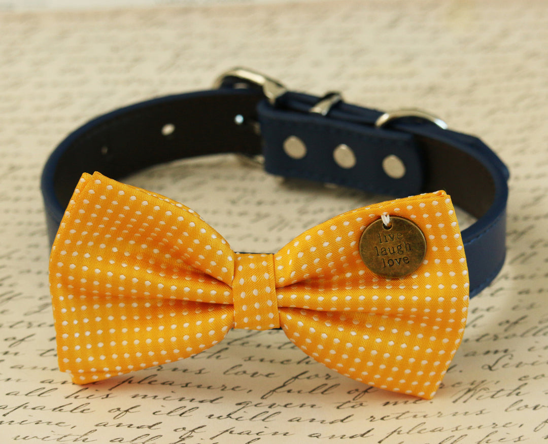 Yellow polka dot dog bow tie with live laugh love charm attached to a navy blue vegan leather collar.